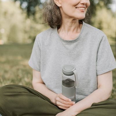 Portrait of Elena Petrova, a calm and smiling wellness guide, in a natural setting.